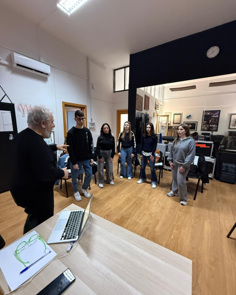 Giovani volontari registrano i contenuti audio del percorso Senza Parole Lizzano in una sala attrezzata con microfoni e cuffie