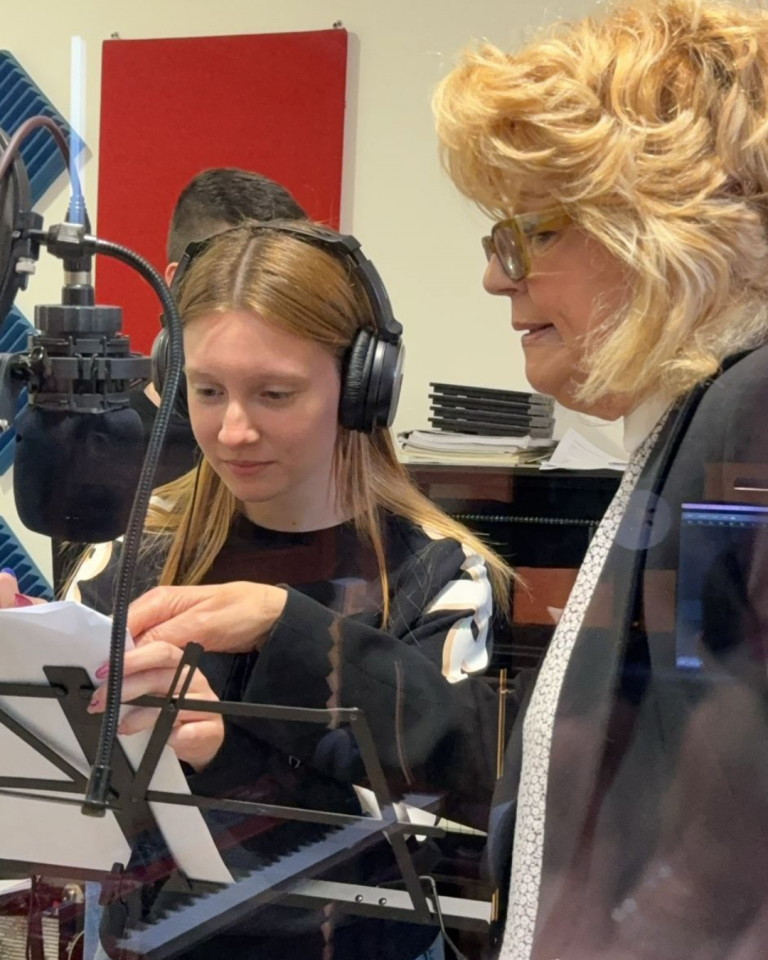 Giovani volontari registrano i contenuti audio del percorso Senza Parole Lizzano in una sala attrezzata con microfoni e cuffie