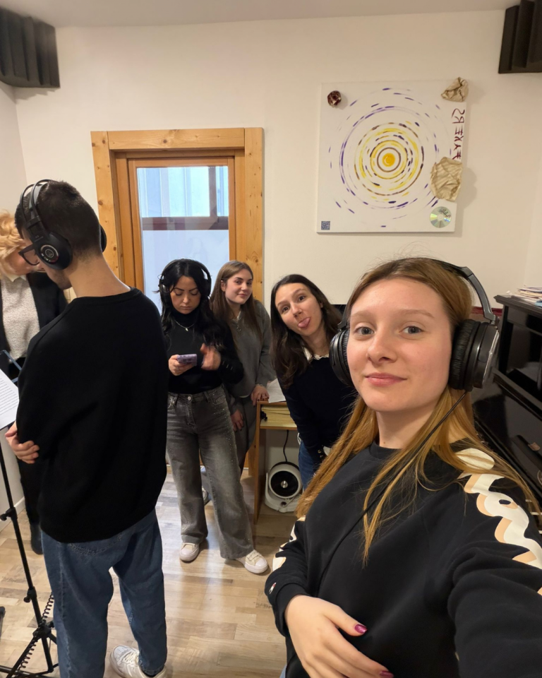Giovani volontari registrano i contenuti audio del percorso Senza Parole Lizzano in una sala attrezzata con microfoni e cuffie