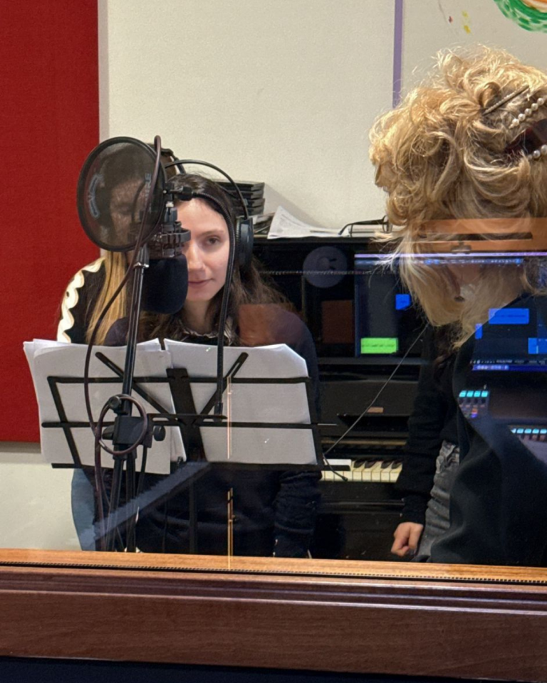 Giovani volontari registrano i contenuti audio del percorso Senza Parole Lizzano in una sala attrezzata con microfoni e cuffie