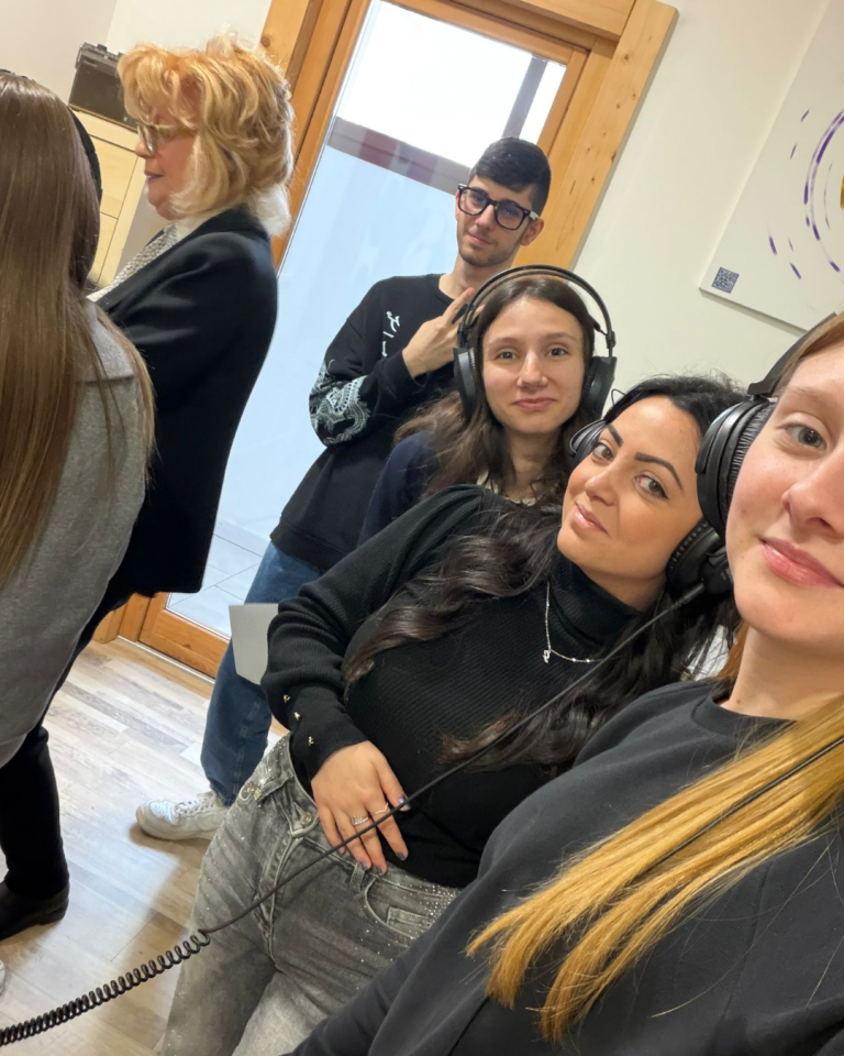 Giovani volontari registrano i contenuti audio del percorso Senza Parole Lizzano in una sala attrezzata con microfoni e cuffie