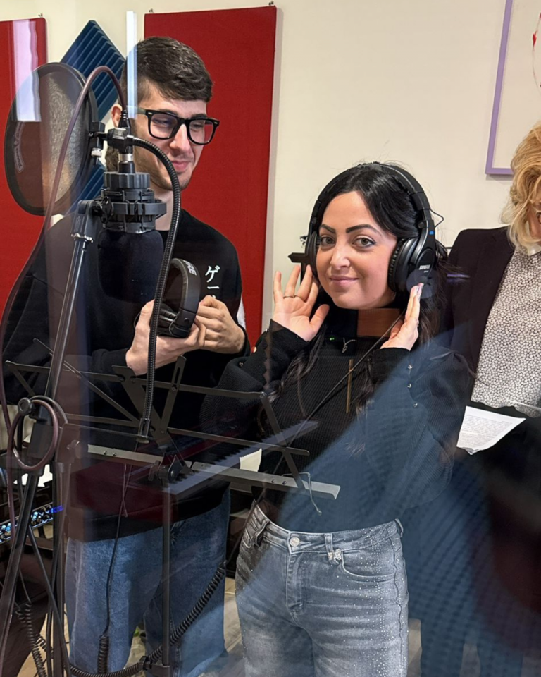 Giovani volontari registrano i contenuti audio del percorso Senza Parole Lizzano in una sala attrezzata con microfoni e cuffie