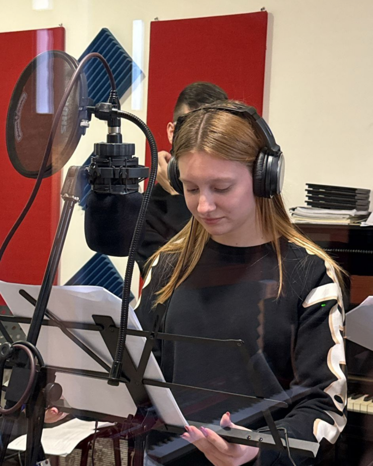 Giovani volontari registrano i contenuti audio del percorso Senza Parole Lizzano in una sala attrezzata con microfoni e cuffie