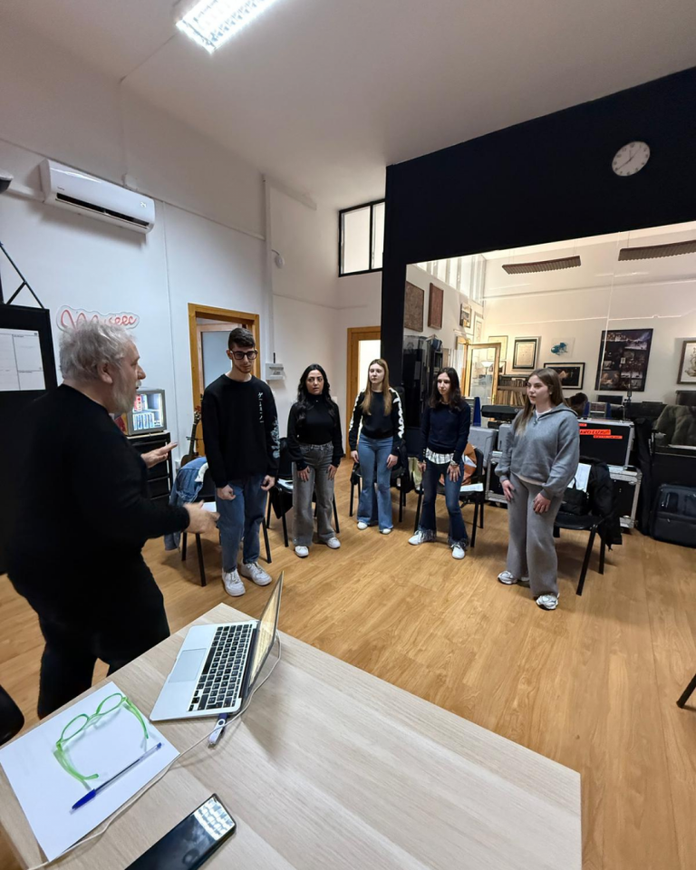 Giovani volontari registrano i contenuti audio del percorso Senza Parole Lizzano in una sala attrezzata con microfoni e cuffie