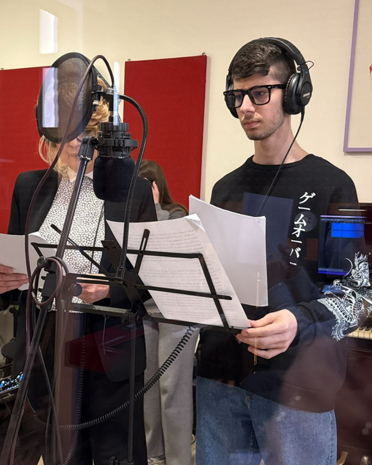 Giovani volontari registrano i contenuti audio del percorso Senza Parole Lizzano in una sala attrezzata con microfoni e cuffie