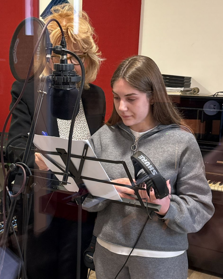 Giovani volontari registrano i contenuti audio del percorso Senza Parole Lizzano in una sala attrezzata con microfoni e cuffie