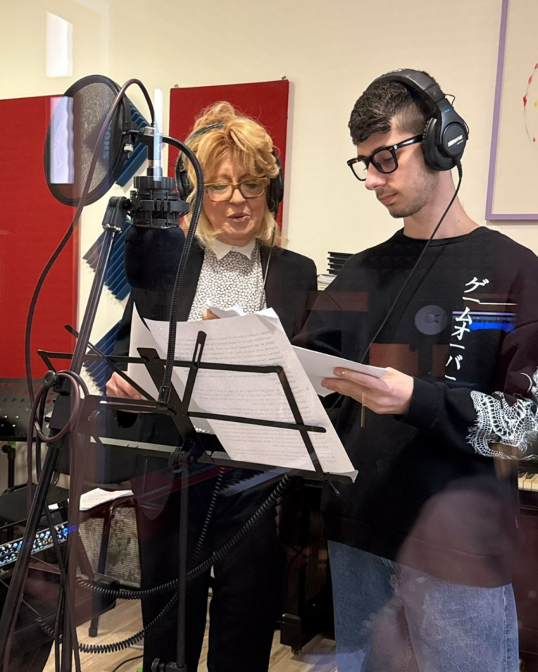 Giovani volontari registrano i contenuti audio del percorso Senza Parole Lizzano in una sala attrezzata con microfoni e cuffie